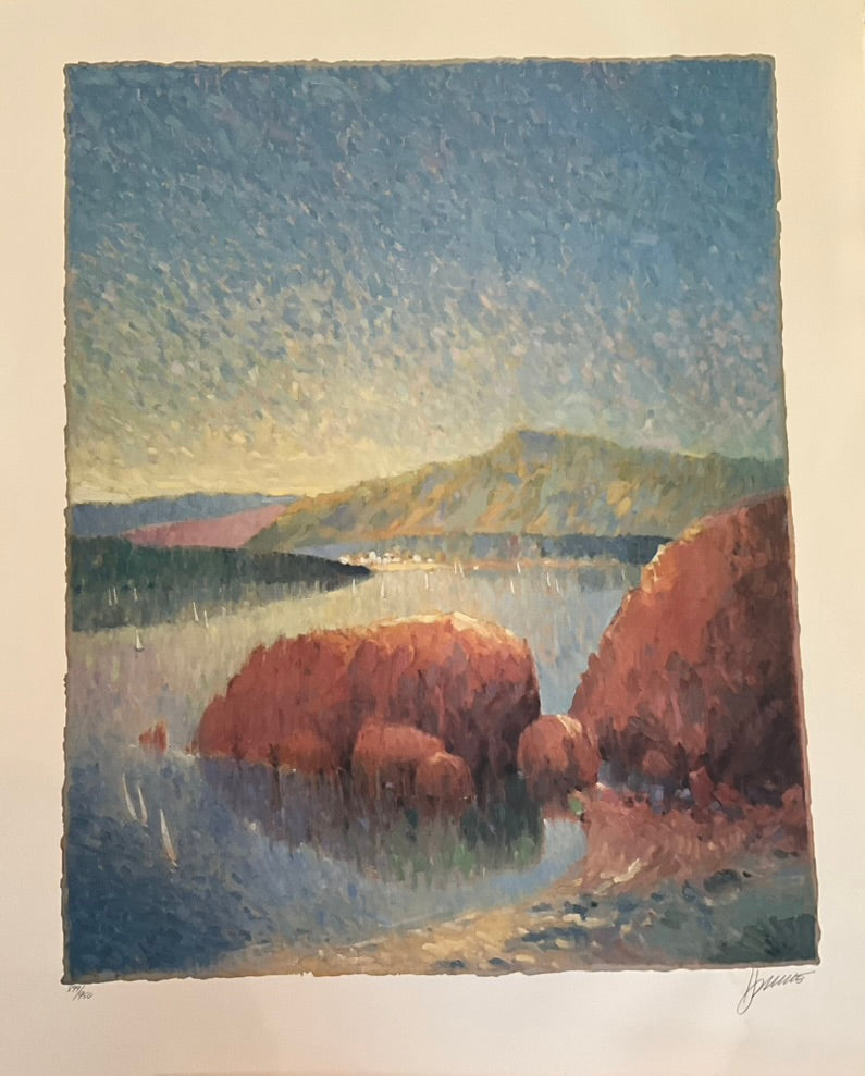 Impressionist landscape painting of a coastal scene with large reddish-brown rocks in calm blue water, distant green hills, and a softly glowing sky. The artwork uses short, textured brushstrokes and warm light to capture a peaceful seaside atmosphere at sunset.