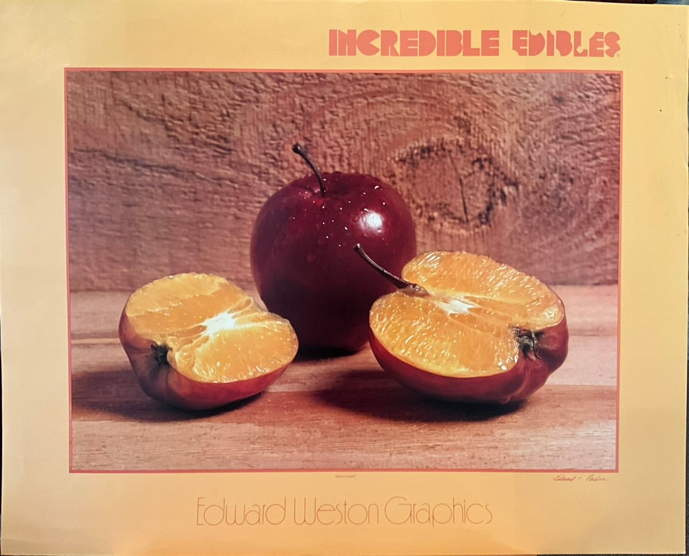 A poster of a still life of two apples, one cut in half revealing an orange underneath the apple's skin.