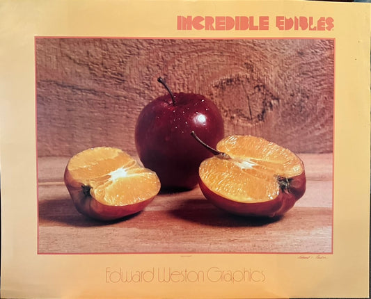 A poster of a still life of two apples, one cut in half revealing an orange underneath the apple's skin.