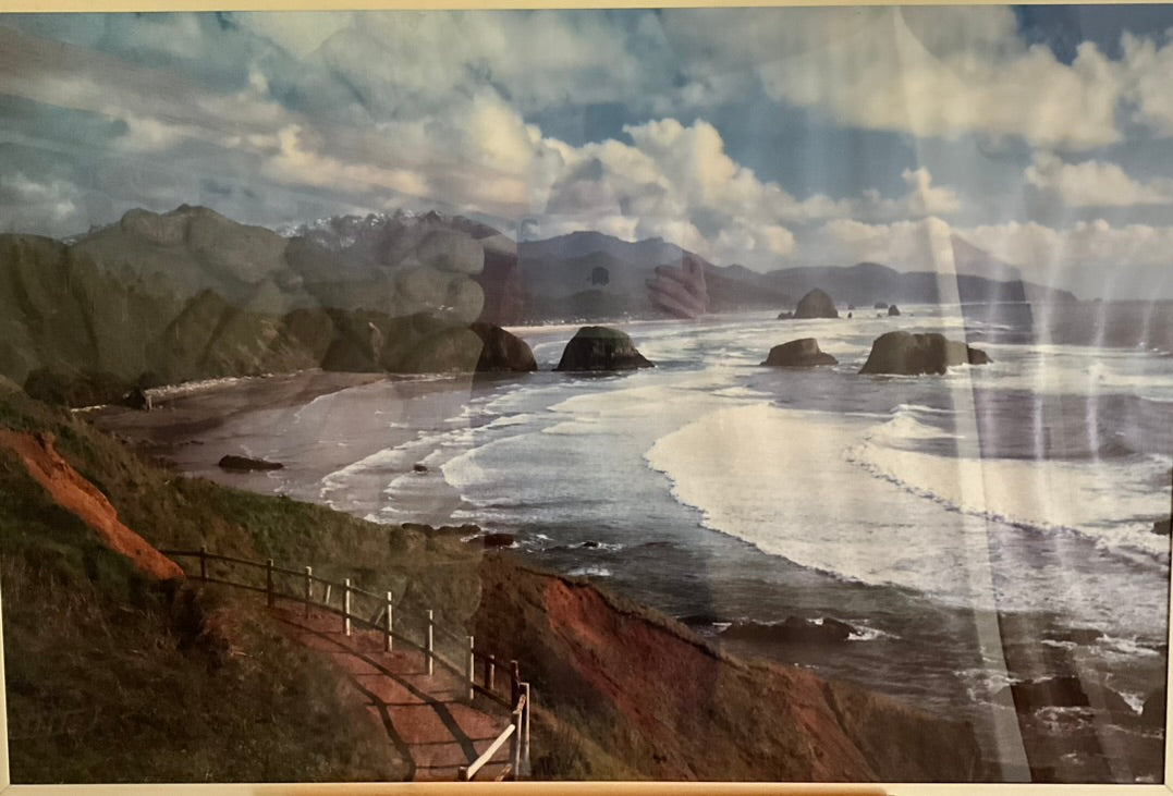 Framed photograph featuring a scenic view of the coast with mountains and ocean.
