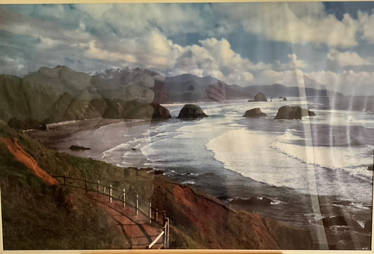 Framed photograph featuring a scenic view of the coast with mountains and ocean.
