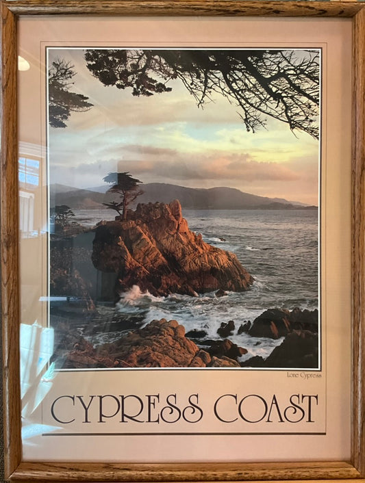A photograph of the lone cypress tree on a rocky shore in central California with a beautiful muted sunset. Underneath the photo reads: CYPRESS COAST in a decorative font.