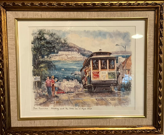 a framed artwork depicting a trolly passing pedestrians on it's way to a the ocean in San Francisco.